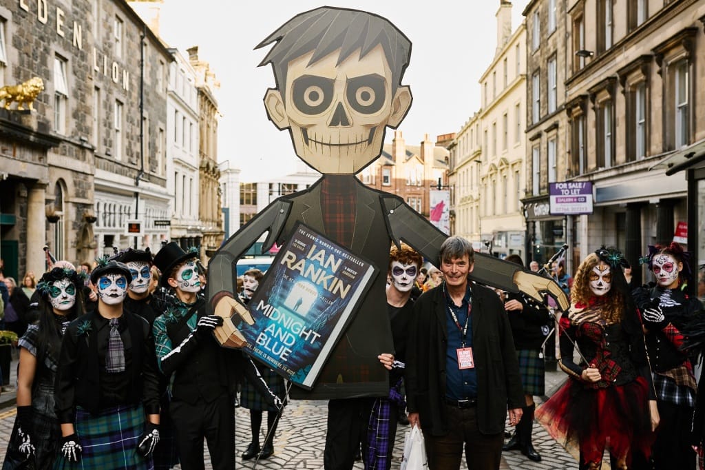 Sir Ian Rankin with a giant 'Day of the Deid' effigy and performers from Rubber Chicken Theatre