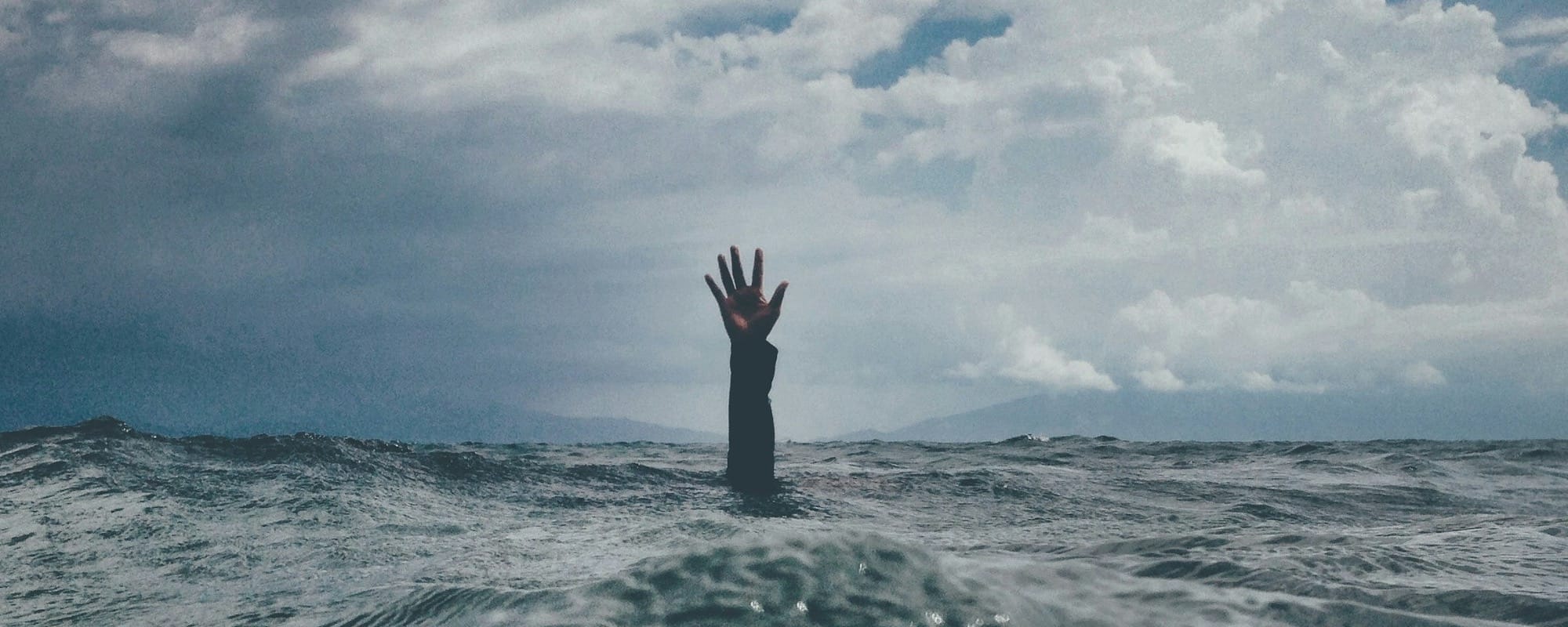 photo of person reach out above the water