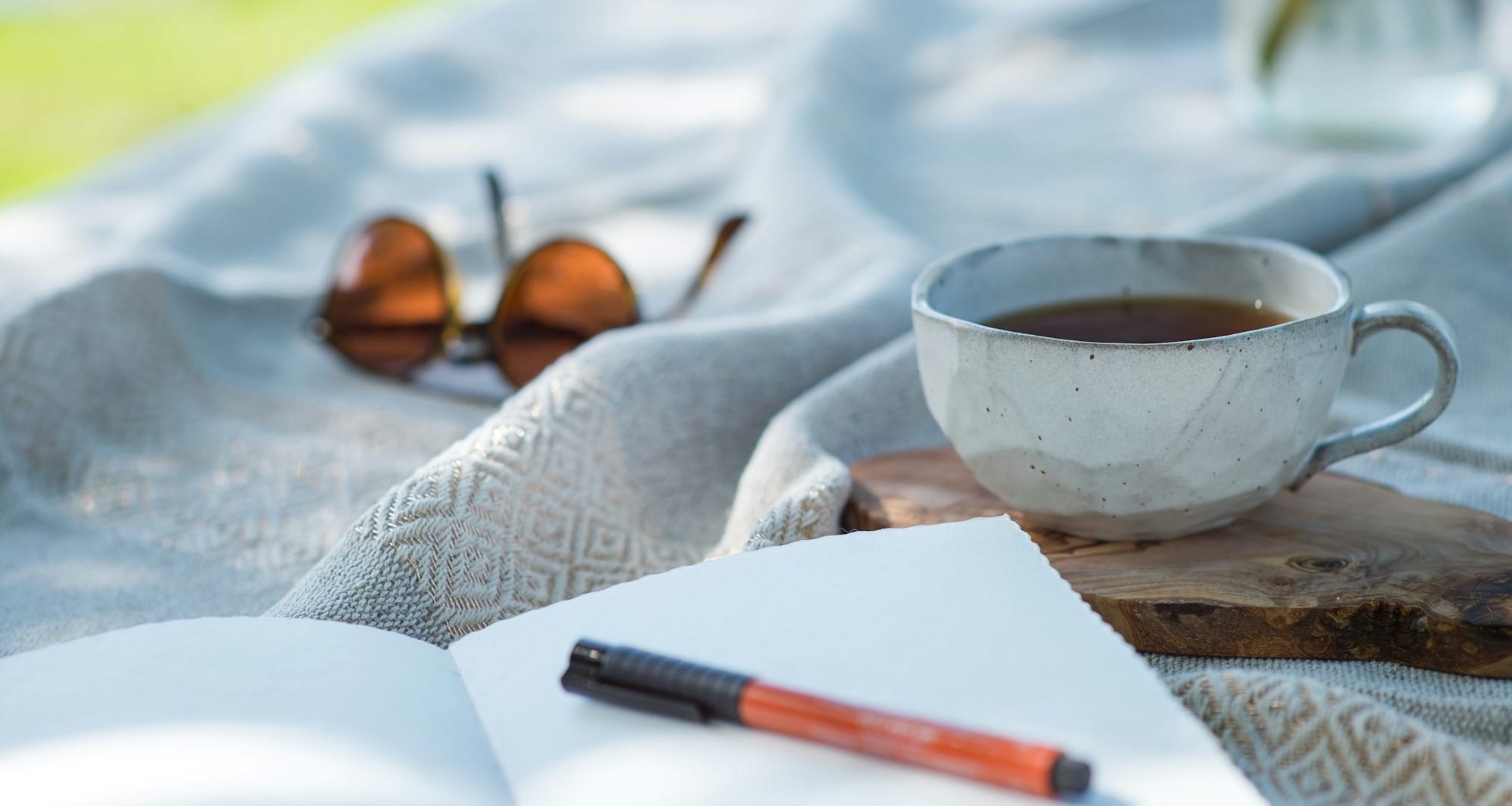 white ceramic cup on white textile
