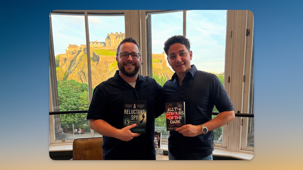 Myself and Chris Whitaker, holding our respective novels, standing in a bay window with Edinburgh Castle in the background